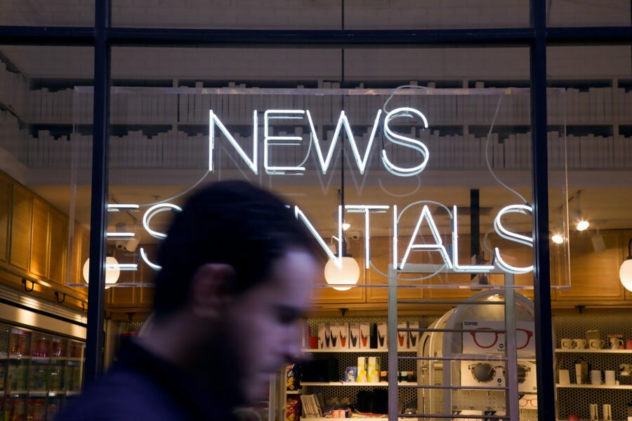 Ein Unternehmer geht an einem Schaufenster vorbei und überlegt, wie er Printmedien nutzen kann.